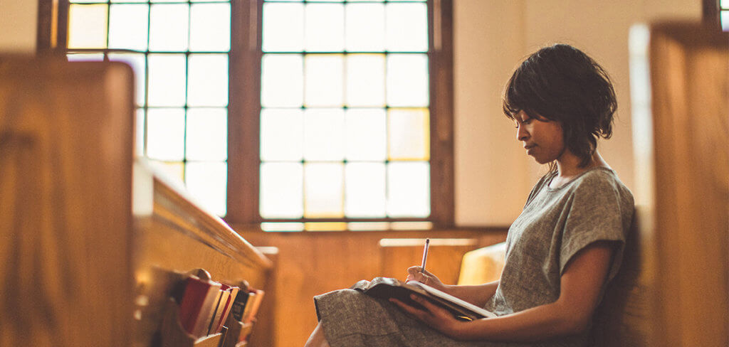 Woman sitting and reading in a church